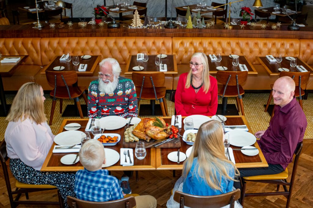 Multi-generational family enjoying a festive meal together at a restaurant in Dubai.