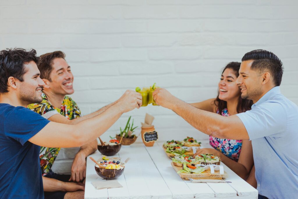 A group of friends enjoying a meal and celebrating with drinks at an outdoor restaurant.